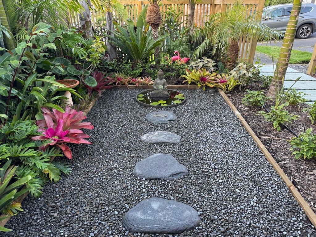 Tropical pebble garden with stepping stones, buddha water feature and bromeliads
